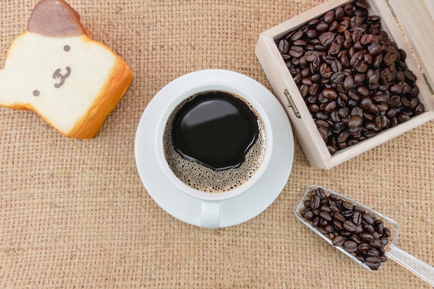 Tasse à café et grains de café sur un sac grossier