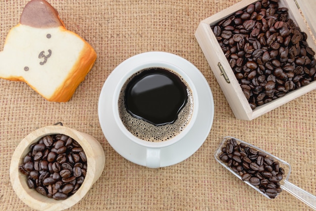 Tasse à café et grains de café sur un sac grossier