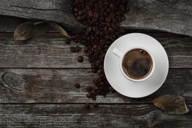 Une tasse de café et de grains de café sur la table. Vue de dessus.