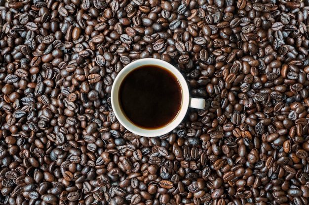 Une tasse de café sur des grains de café torréfiés