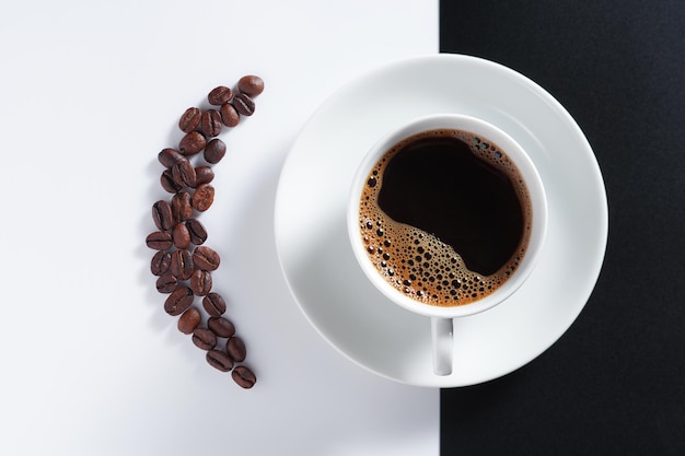 Tasse de café et de grains sur fond blanc noir bouchent la vue de dessus