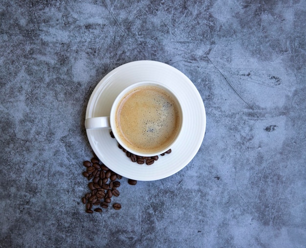 tasse de café avec des grains sur fond gris