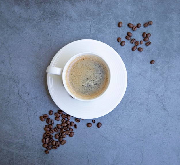 tasse de café avec des grains sur fond gris