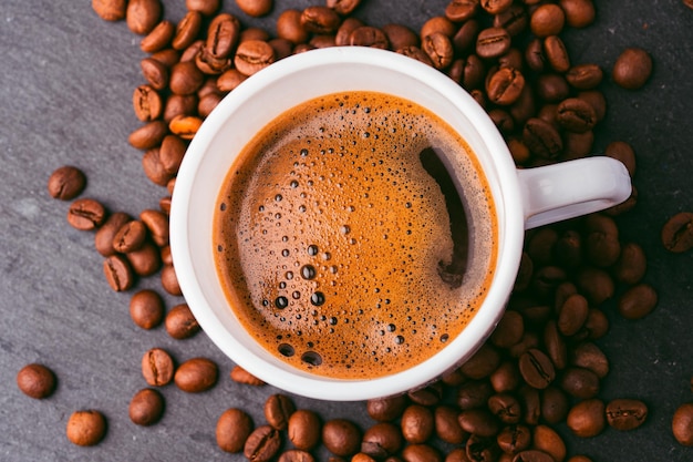 Une tasse de café avec des grains sur la table