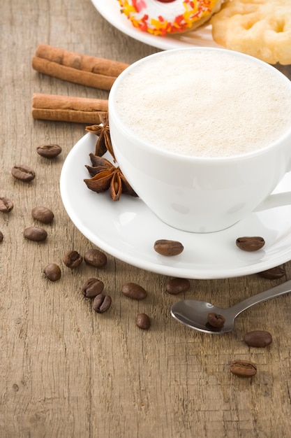 Tasse de café avec des grains sur la texture de fond du bois