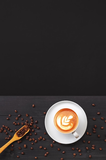 Tasse de café et de grains sur la vue de dessus de fond de table en bois noir