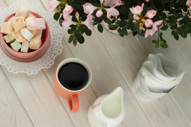 tasse de café avec guimauve sur une table en bois blanc