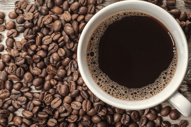 Tasse de café et haricots sur bois