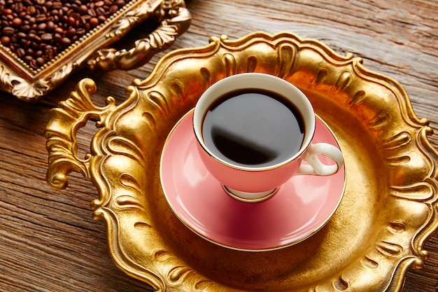 Tasse à café et haricots sur plateau doré vintage