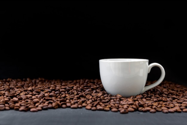 Tasse de café et de haricots sur une table en bois noire