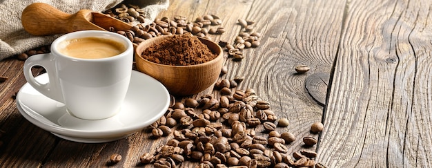 Tasse à café et haricots sur une vieille table en bois.