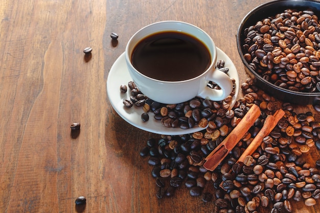 Tasse à café et haricots sur la vieille table en bois