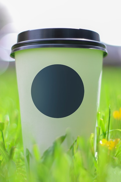 Photo tasse de café sur l'herbe verte avec dof peu profonde