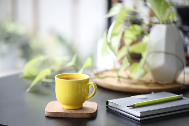 Tasse à café jaune et carnet et cache-pot