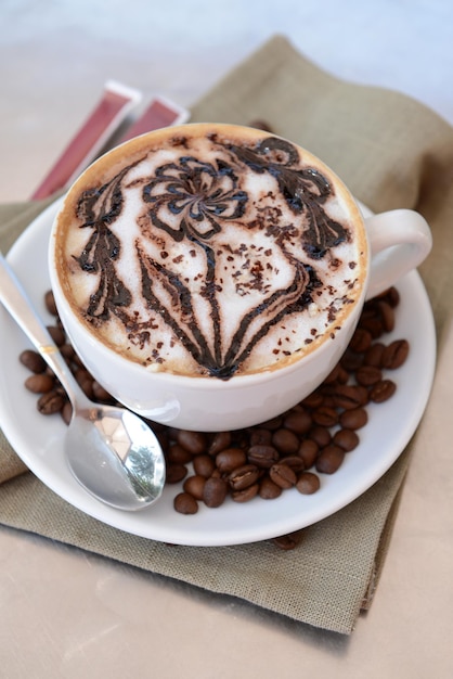 Tasse de café avec un joli dessin sur la table en gros plan