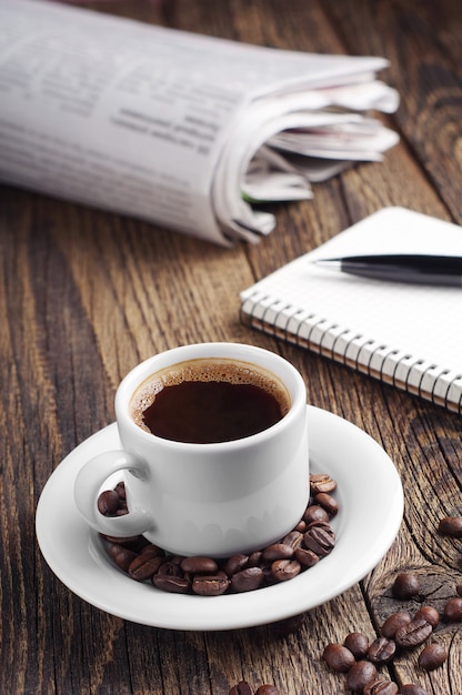 Tasse à café et journal sur table en bois vintage