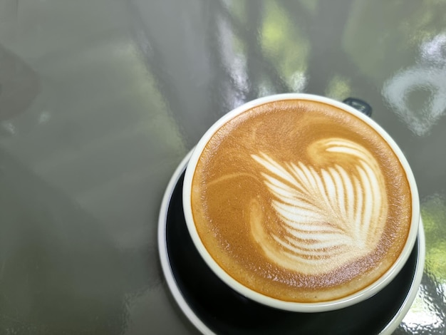 Une tasse de café latte art chaud sur table