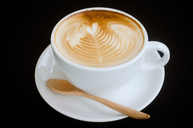 Une tasse de café (latte art) sur fond noir