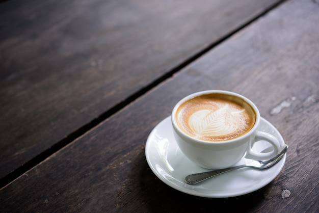 tasse de café latte art sur la table en bois