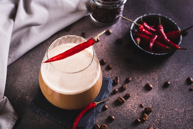 Une tasse de café latte épicé avec du piment rouge sur la table.