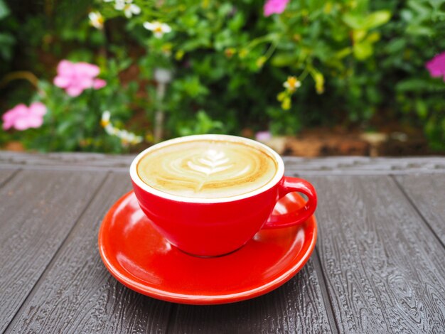 Tasse De Café Latte Rouge Sur Une Table En Bois Dans Le Jardin.