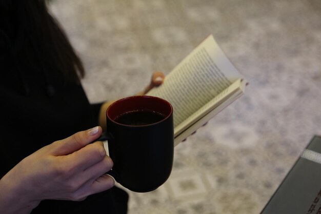 Une tasse de café en lisant un livre ou un magazine