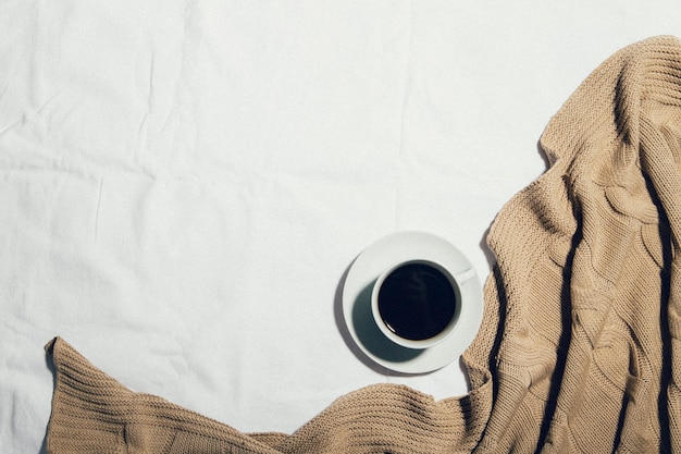 une tasse de café sur un lit blanc