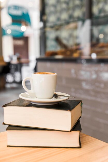 Photo une tasse de café, des livres, une table en bois