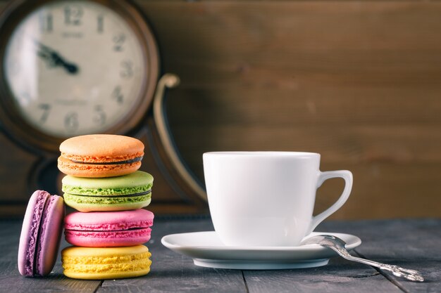 Tasse de café et macaron français sur une vieille table en bois.