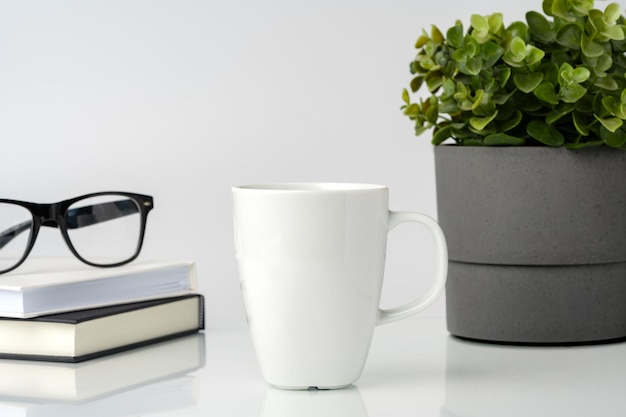 Photo une tasse de café sur une maquette de table de bureau blanche