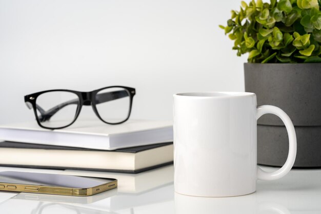 Photo une tasse de café sur une maquette de table de bureau blanche