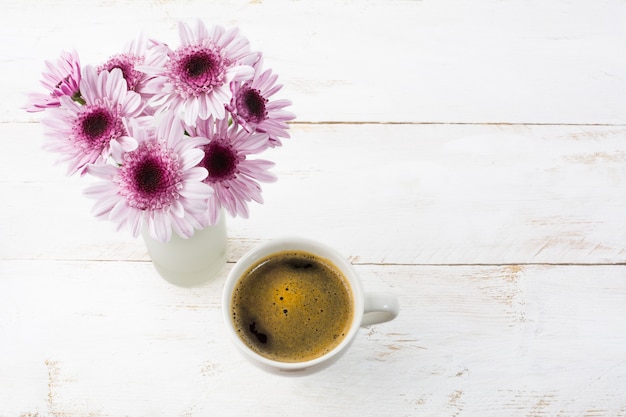 Tasse à café et marguerites lilas, vue de dessus