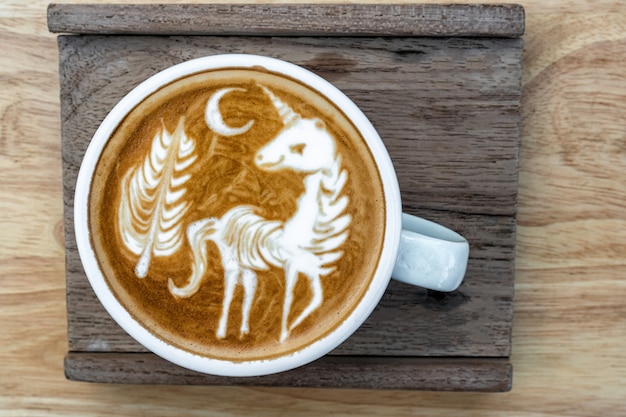 Une tasse de café avec un menu d&#39;art latte qui montrent la licorne et l&#39;arbre