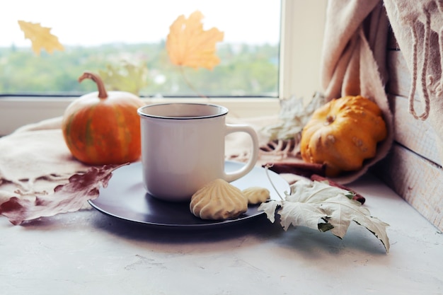 Tasse de café meringue citrouille laisse une couverture chaude sur le concept de confort à la maison de rebord de fenêtre