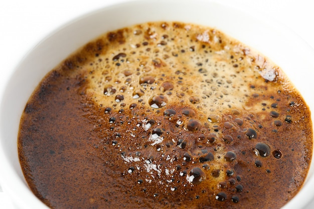 Tasse de café avec mousse mousseuse sur fond blanc