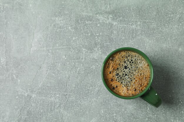 Tasse de café avec mousse mousseuse sur fond gris