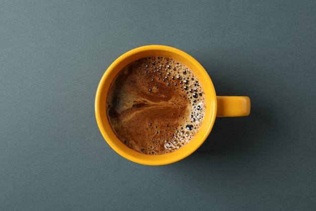 Tasse de café avec mousse mousseuse sur fond noir