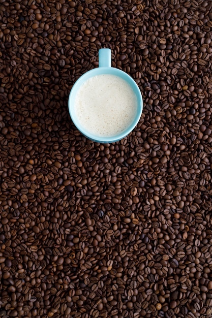 Tasse de café sur un mur de grains de café avec espace copie