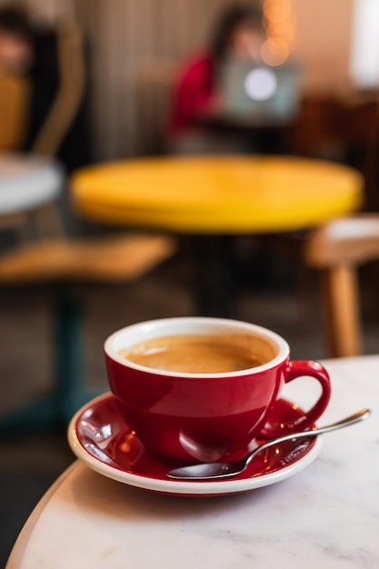Une tasse de café noir sur le bord d'une table en marbre dans un café-café avec espace de copie