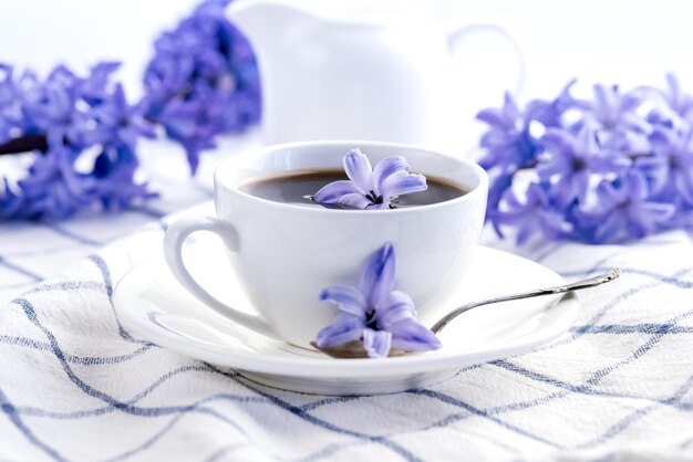 Tasse de café noir et de fleurs de jacinthe pourpre sur la serviette