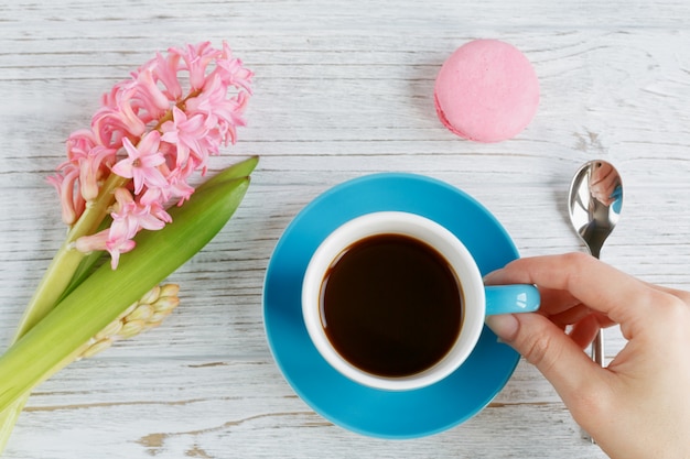 Tasse de café noir, fleurs roses et macarons français