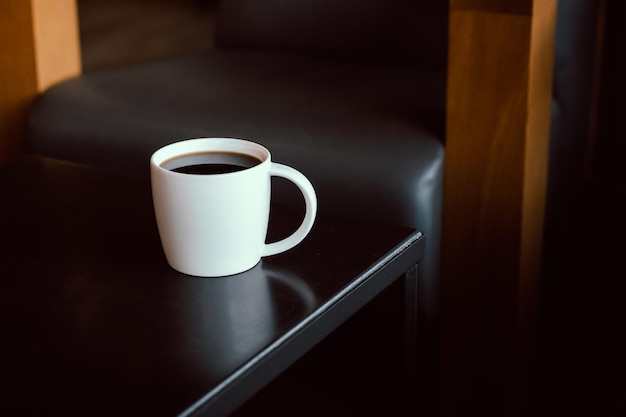 Tasse de café noir frais sur table en bois