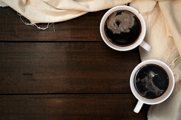 Tasse à café noir gros plan sur la vue de dessus de planche de bois