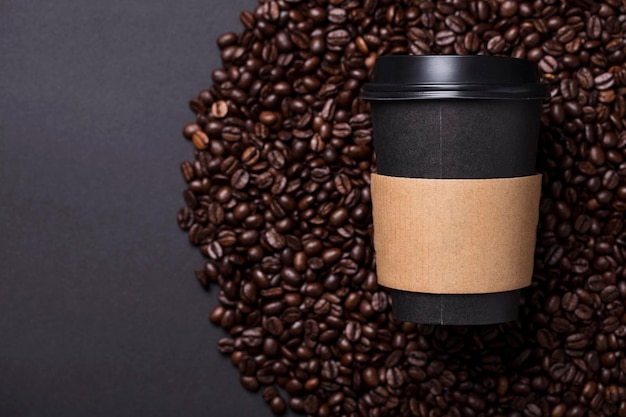 Tasse à café noire à emporter avec grains de café torréfiés