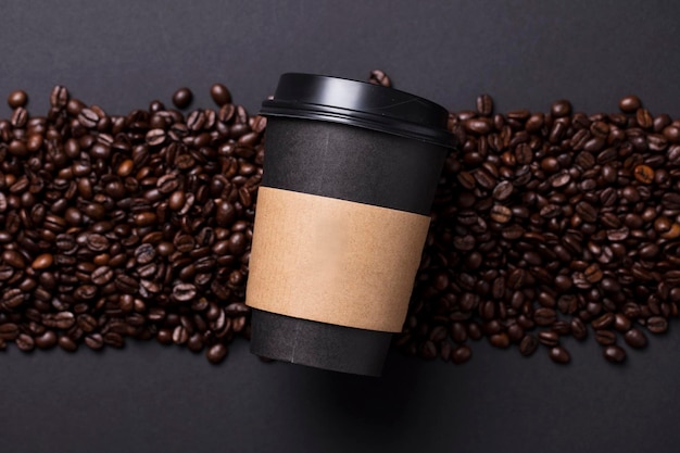 Tasse à café noire à emporter avec grains de café torréfiés