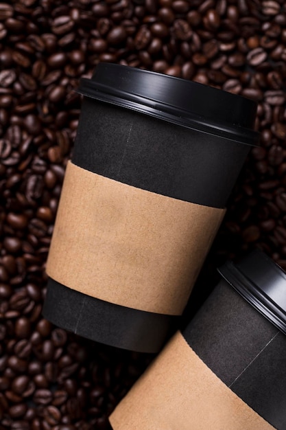 Tasse à café noire à emporter avec grains de café torréfiés