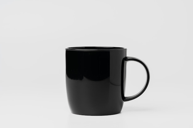 Une tasse de café noire sur fond blanc