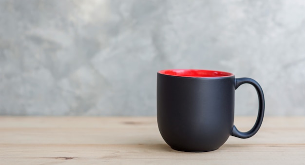 Tasse à café noire sur un fond en bois.