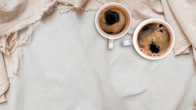 tasse de café noire mise en gros plan sur un tissu de lin vue supérieure