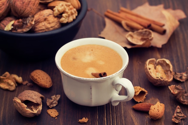 Une tasse de café et de noix sur une surface en bois